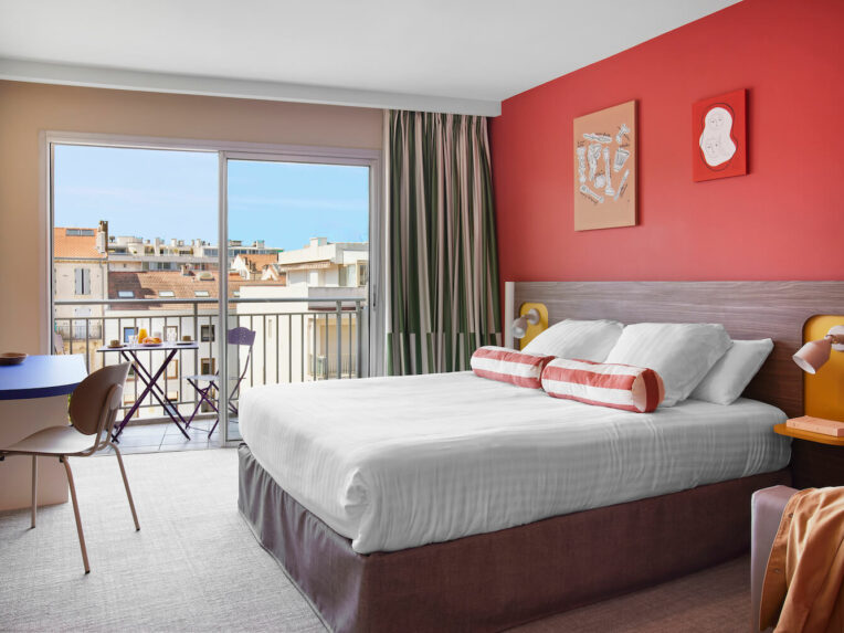 Chambre de l’hôtel Abrial Cannes Centre du Groupe hôtelier Soniho rouge vue sur Cannes