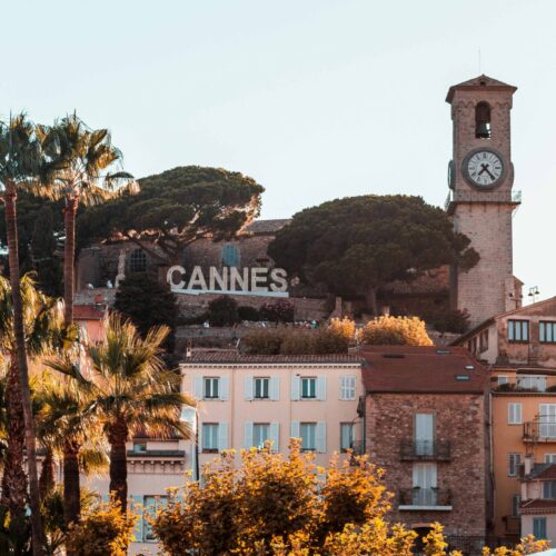 Vue sur une colline de cannes avec marqué « Cannes » à côté du cloché d’une église cannoise