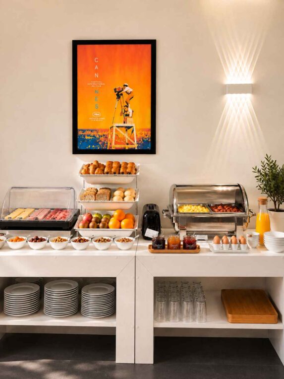 Buffet de petit-déjeuner de l’Hôtel Abrial à Cannes avec viennoiseries, fruits, œufs, charcuterie et boissons chaudes.