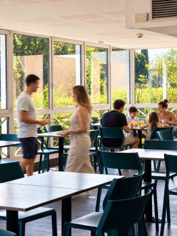 Famille avec deux enfants prenant son petit-déjeuner dans la salle lumineuse de l’Hôtel Cyano à Fréjus.